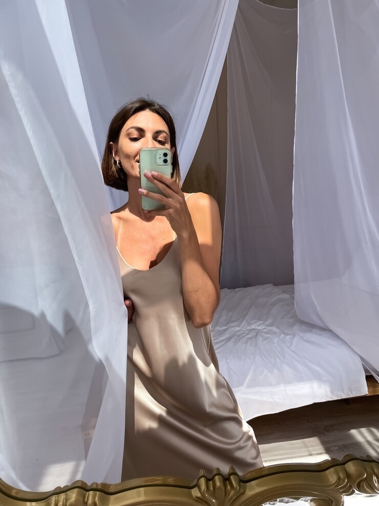 20250129194901-ad0df4f1e272-fit-tanned-woman-romantic-beige-silk-dress-home-takes-photo-selfie-phone-mirror_343596-6457.jpg